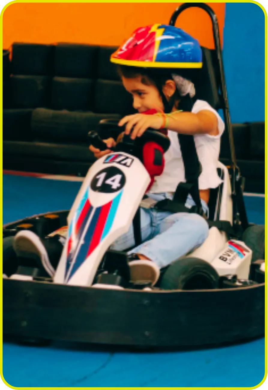 Criança pequena pilotando kart elétrico infantil com segurança na eKarts