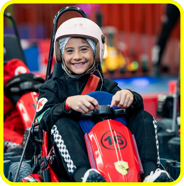 Criança de capacete pilotando kart elétrico infantil na eKarts em BH
