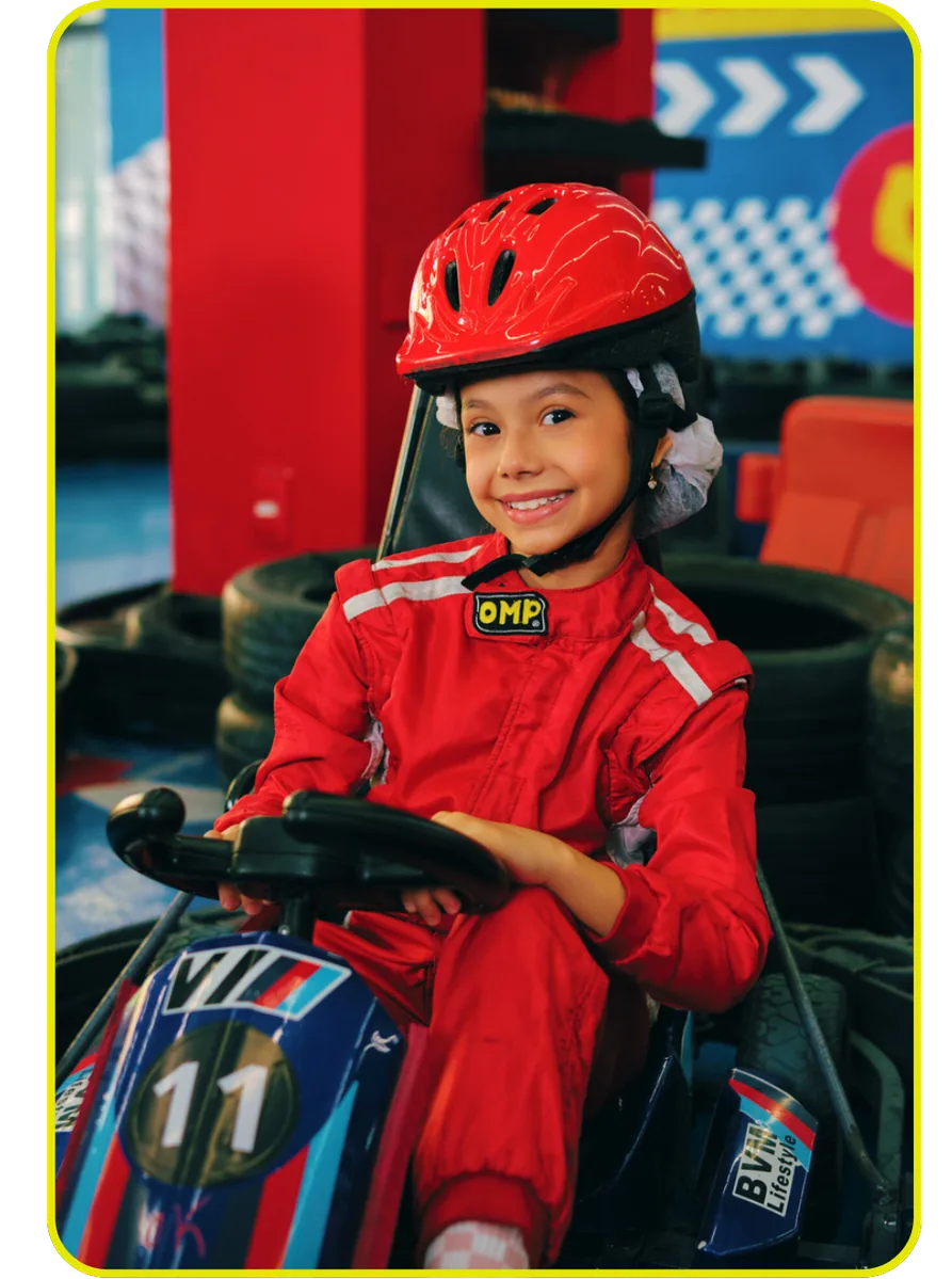 Criança de macacão vermelho de corrida pilotando kart elétrico na eKarts