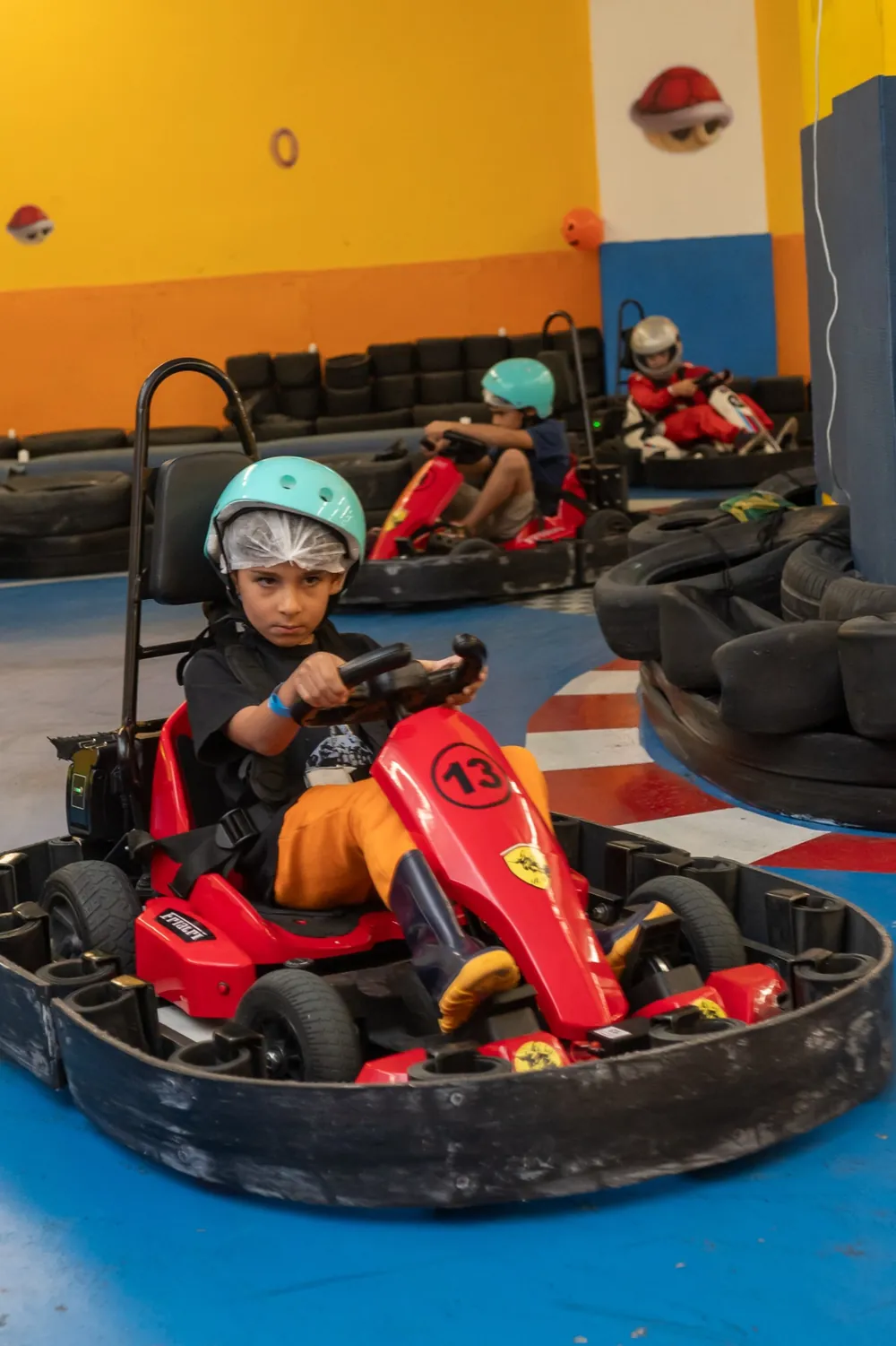 Menino concentrado pilotando o kart na pista