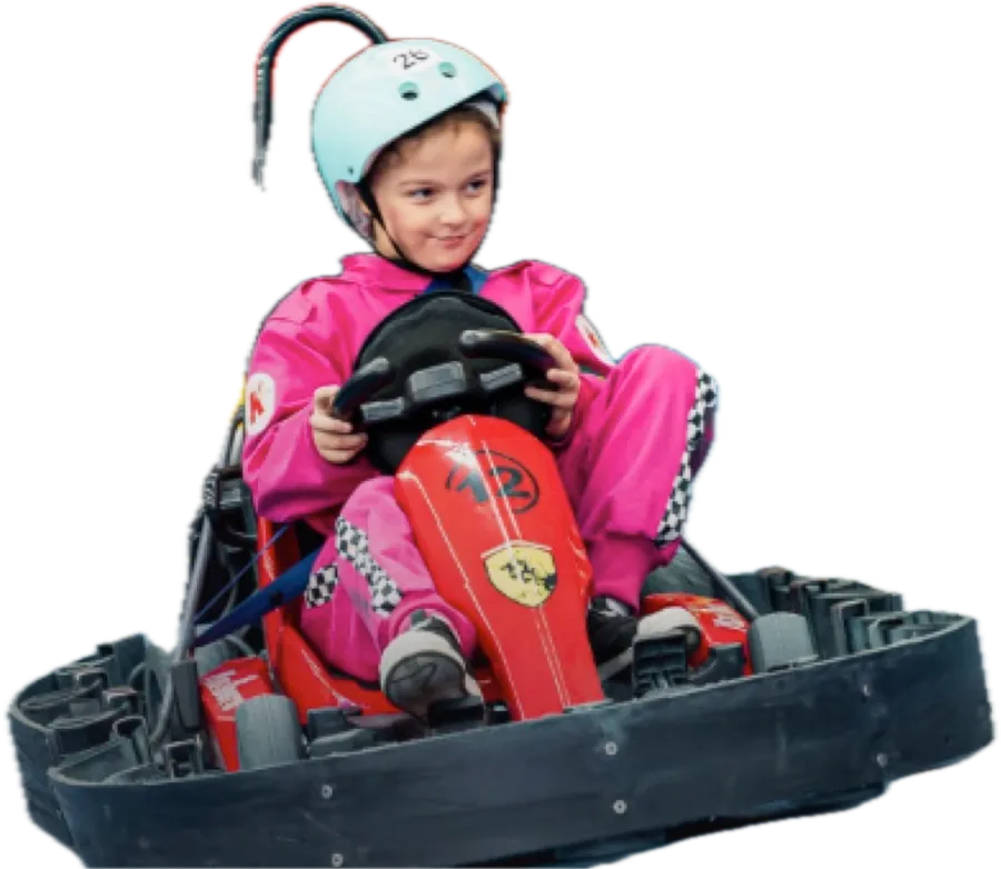 Menina de macacão rosa e capacete pilotando um kart elétrico vermelho