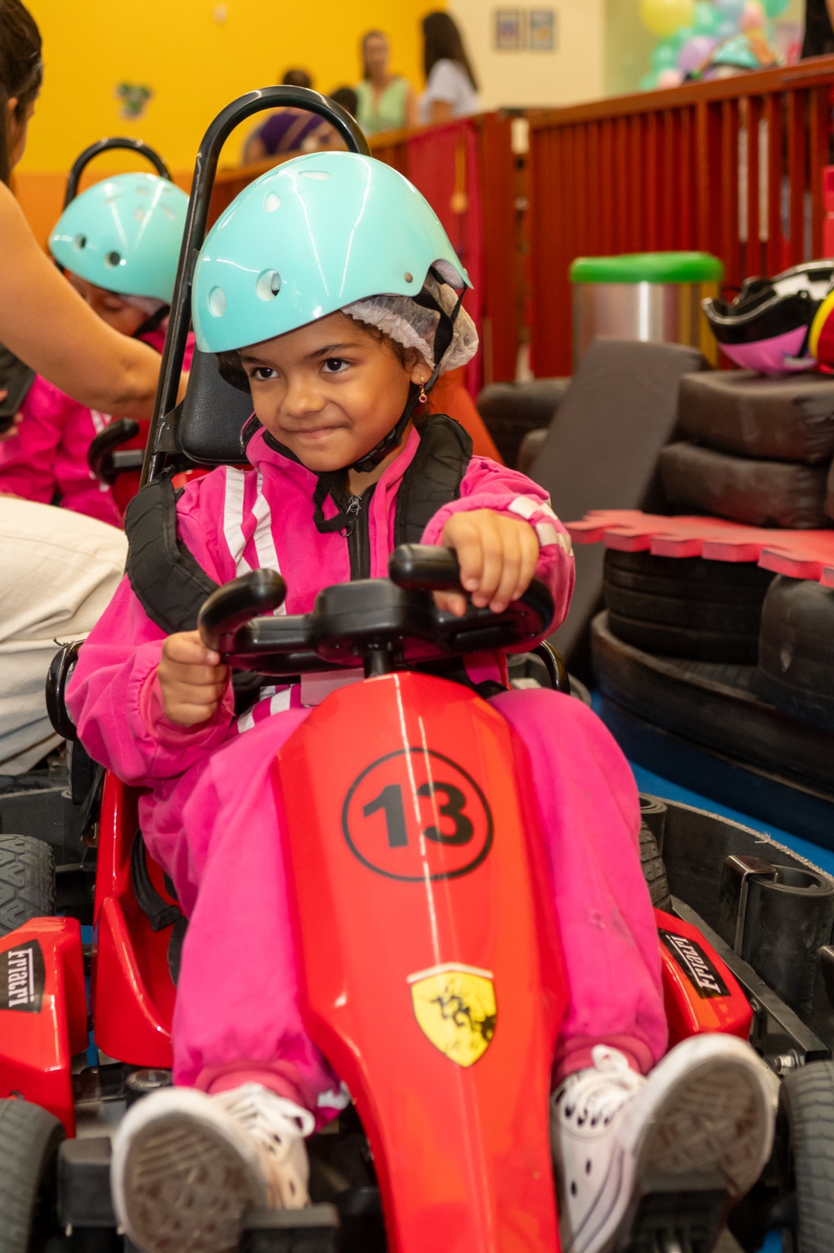 Menina sorrindo com balões coloridos em uma festa no eKarts